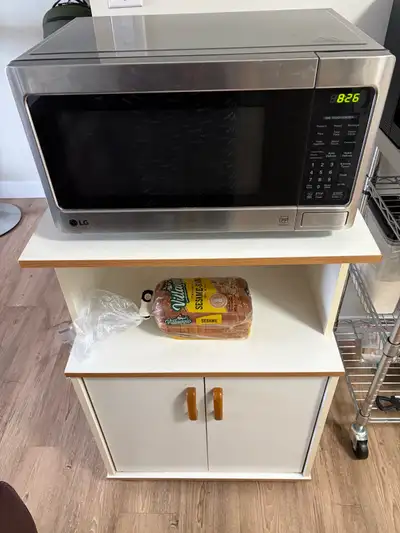 Microwave and wheeled stand for sale. 4 year old LG 800W microwave oven. *interior light does not li...