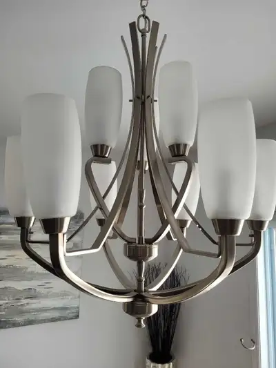 Stainless steel suspended chandelier with additional light bulbs.