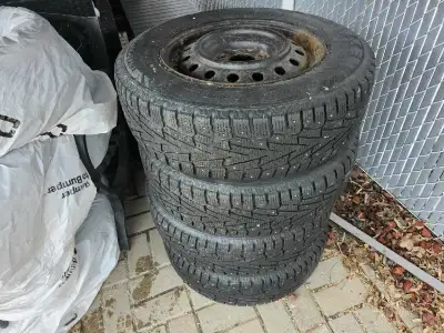 These are a set of four winter tires mounted on steel rims, size 215/70R16, that came off of a Kia S...