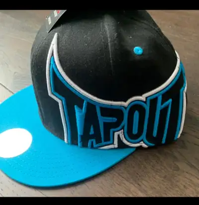 Get ready to top off your look with this TapouT baseball cap! This hat is in good condition and feat...