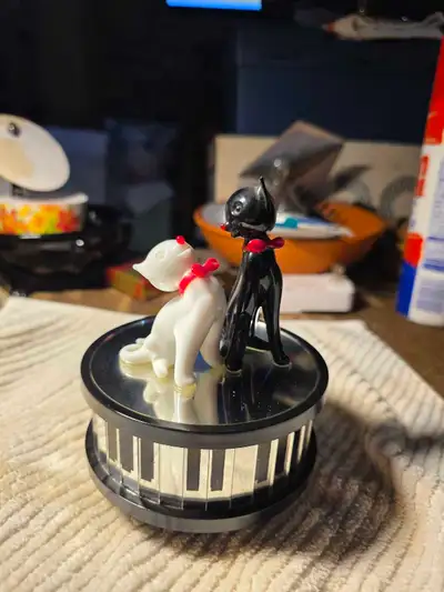 This charming used Enesco music box features two adorable cats, one black and one white, sitting ato...