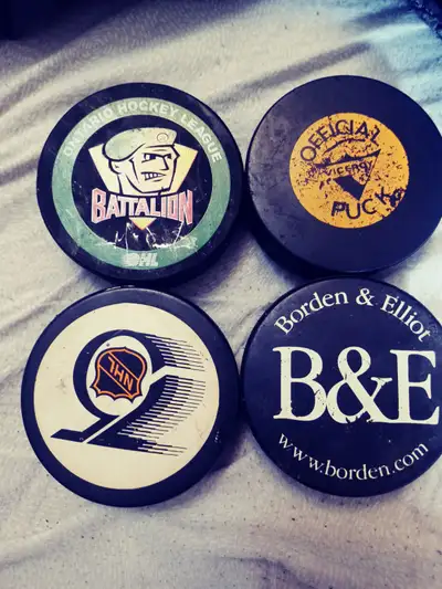 4 vintage hockey pucks, one with an autograph., View more