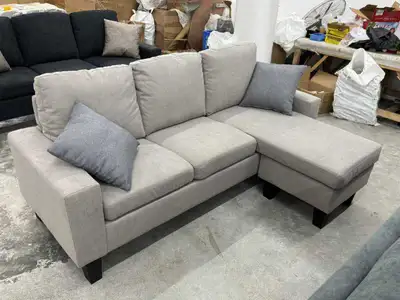 This stylish light grey sectional sofa features a chaise lounge and offers comfortable seating for y...