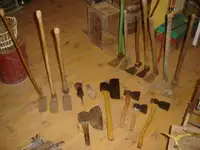 Plusieurs outils anciens, hache à équarrir, herminette, râteaux