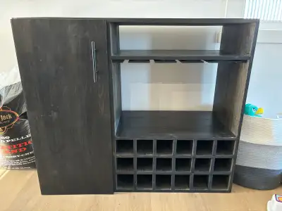 Cabinet with wine/liquor bottle holes and places to hold wine glasses upside down. Used top of it fo...