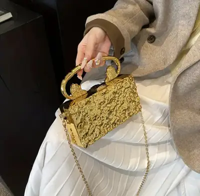 This stunning gold clutch is a statement piece that's sure to turn heads, featuring a unique texture...