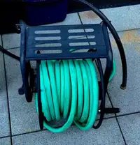Metal garden hose reel with shelf, hose and nozzle