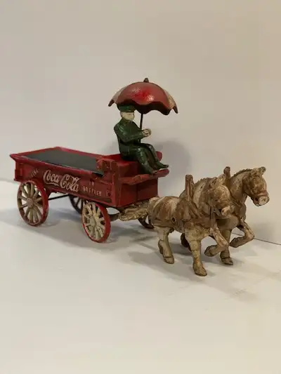 Cast iron Coca Cola collectors item with horse drawn carriage including wagon, umbrella and driver....