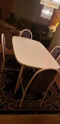 White table and four metal upholstered chairs.
