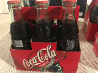 4 sets of 6 pack of coke with name of bottles company on bottom