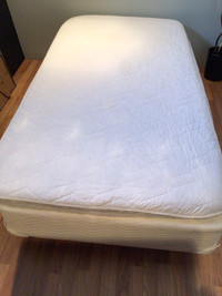 Base de lit simple avec un petit matelas.
