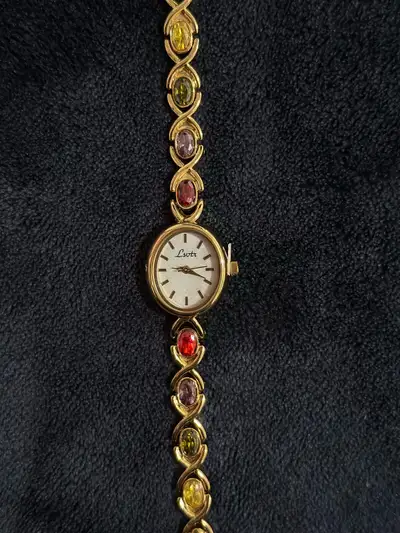 Gold tone with colorful stone watch. Has a watch adjuster tool so you can resize it yourself.