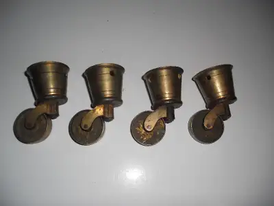 set of four vintage brass swivel furniture cup style casters with wheels 1 3/4 inch diameter.