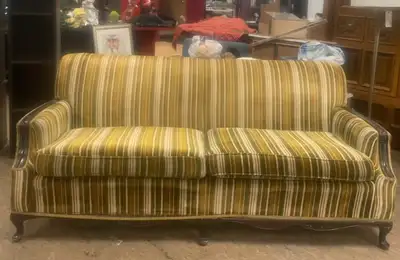 This vintage sofa features a unique striped pattern in shades of green and white, perfect for adding...