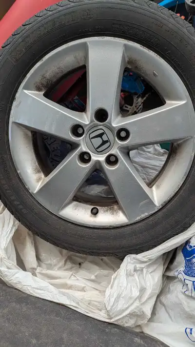 Selling a single, used Honda rims with tires, sized at 205/55R16. Tires are. Pretty much at their we...
