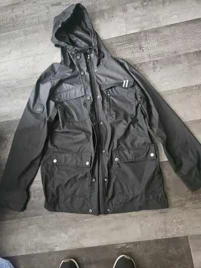 Stay dry and stylish with this sleek black Canada Goose rain jacket, featuring a durable, water-resi...