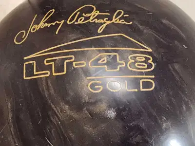 This is a used Johnny Petraglia Brunswick LT-48 Gold vintage bowling ball, a great piece of equipmen...