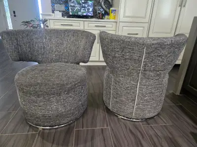 Two black and white chairs that spin., View more