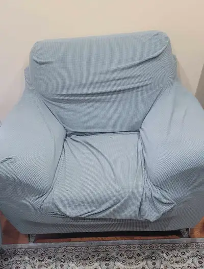 Comfy and spacious single-seater armchair couch, covered in a washable grey slipcover for a neat, ne...