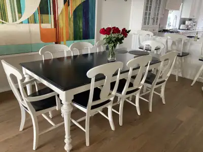 Solid wood dining table and eight chairs - 2 with arms. Dark navy and white in colour. Made in Canad...