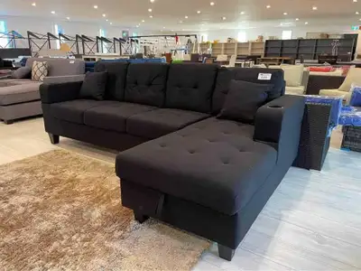 Sink into relaxation with this sleek black couch featuring a convenient storage ottoman, perfect for...