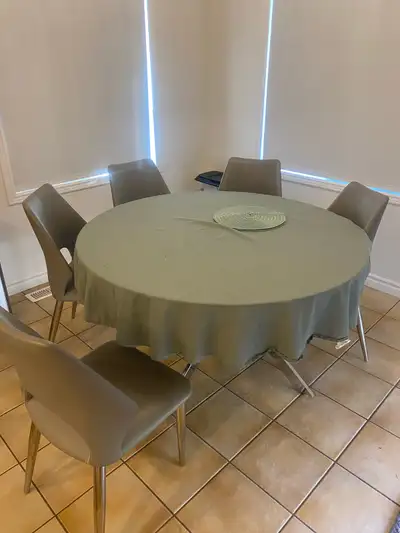 This round glass dining table comes with six chairs. The set is in good condition and features a neu...