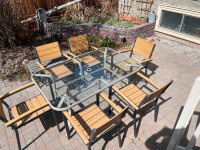 Patio set- 1 used glass top table, 6 new stacking chairs