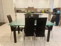Glass dining table with 6 leather chairs in great condition.