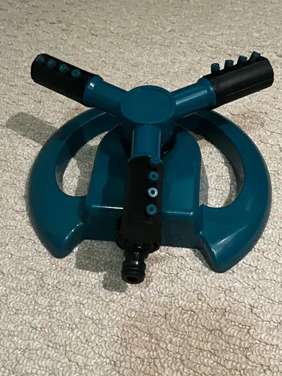 Keep your lawn green with this used three-arm garden sprinkler, designed to provide even water distr...