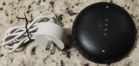 Google Home Mini (1st gen) with a charger