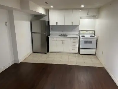 Newly renovated basement apartment featuring a modern kitchen, new hardwood floors, and pot lights t...