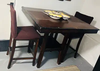 Solid wood pub table with 4 chairs Only two chairs are shown, but there is four I purchased slip cov...