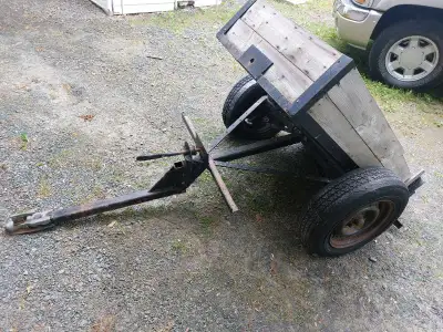 This reliable used yard trailer features a sturdy steel frame, a durable metal floor, and wooden sid...