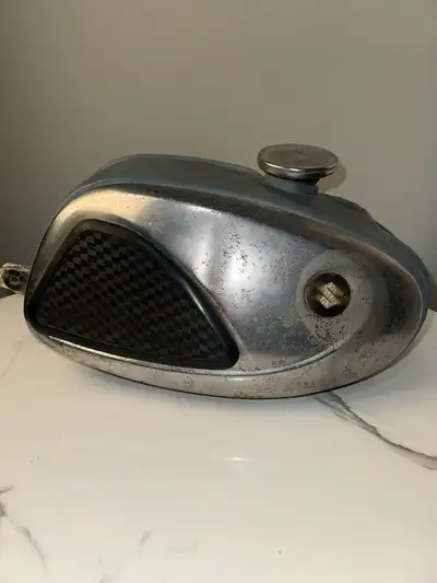 For sale is a vintage Suzuki motorcycle gas tank from a small-bore two-stroke model, likely from the...