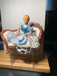 Old Figurine of a Woman Sitting on the Sofa