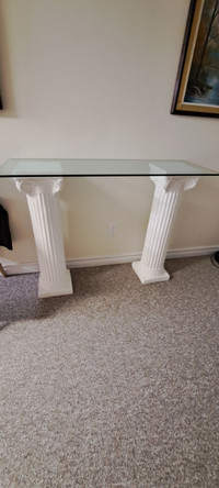 Two white pillars 3 feet  high with a 4 foot glass top for sale.