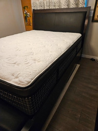 Queen bed frame with mattress and night table.