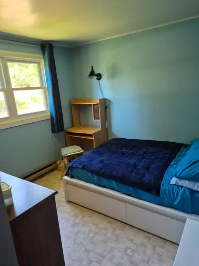 Private bedroom in a house,in a rural area furnished with a bed, night table, dresser, and a desk.Al...