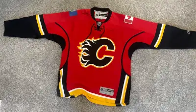 This is a Calgary Flames hockey jersey from Reebok. It's officially licensed by the NHL and features...