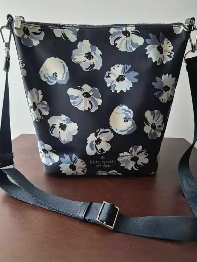Sac Kate Spade en toile satinée, couleur bleu avec fleurs. Comme neuve portée a quelques reprises se...