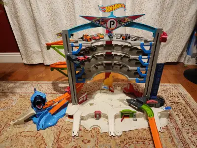 Hot Wheels garage with an box of miscellaneous tracks and accessories, as well as 35 cars. Pick up n...