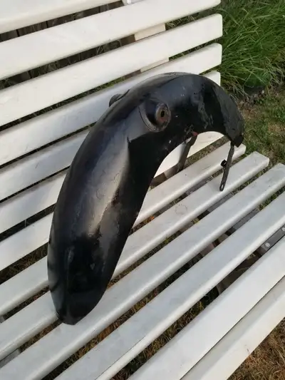 This is a used motorcycle fender, possibly for a vintage bike, showing signs of wear but still funct...