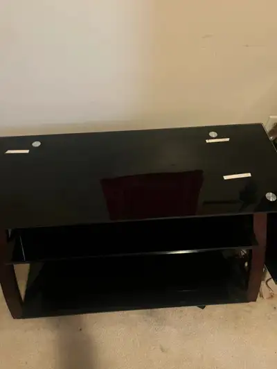 Upgrade your entertainment area with this sleek, used black glass TV stand, offering a modern look a...