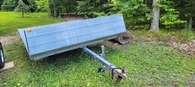 2002 double wide Snowmobile trailer. Good tires. Tilting Bed. 2" ball.