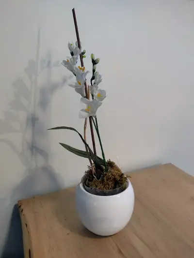 Simple and lovely faux flower planter with two branches of artificial white freesia in a pot. Excell...
