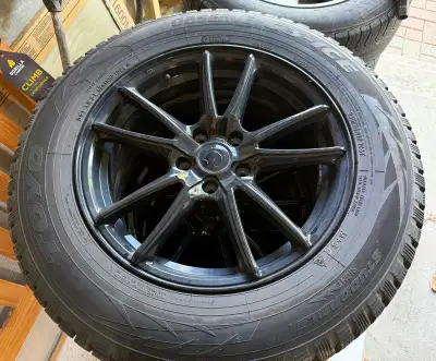 These Toyo Observe G3-Ice winter tires, sized 235/65R17 108T, are mounted on black alloy rims and ar...