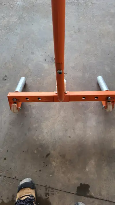 Tire lifter for helping change tires. Rollers to enable spinning tire to align wheel lugs. Adjustabl...