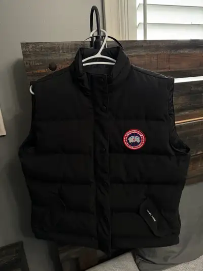 This is a Women’s XL Canada Goose Vest in good condition. It features a classic black design with th...