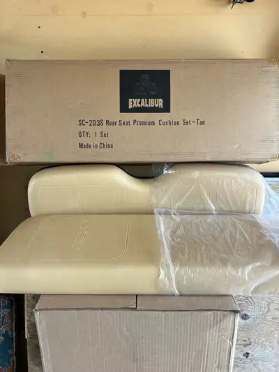 New, in box, golf cart rear seat replacement cushions. Tan color. If interested, call Jon at 403-505...
