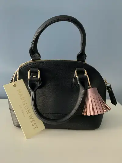 NEW item. Structured shape, zipper closure, two pockets inside (one with zipper), detachable strap....
